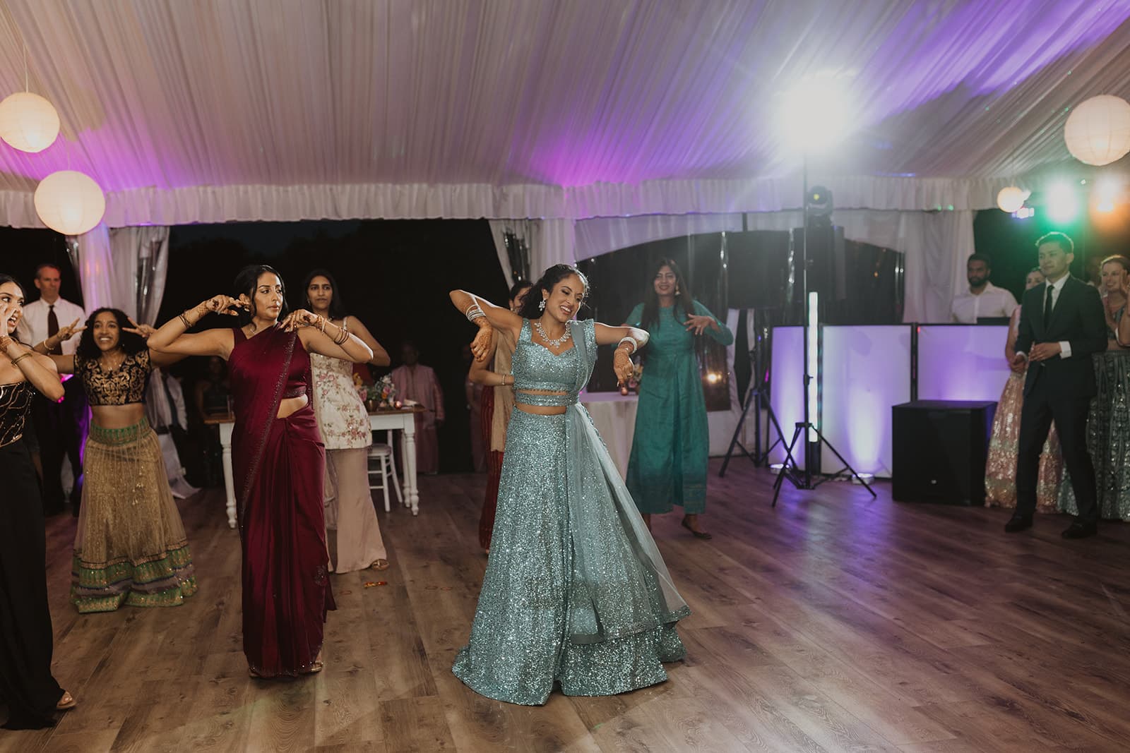Bride and bridesmaids dancing with purple uplighting