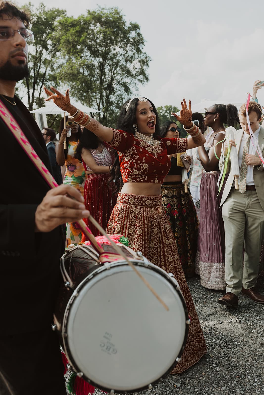 Bride dancing joyfully with dhol player