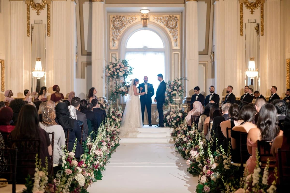 Wedding ceremony in ornate ballroom with elegant decor
