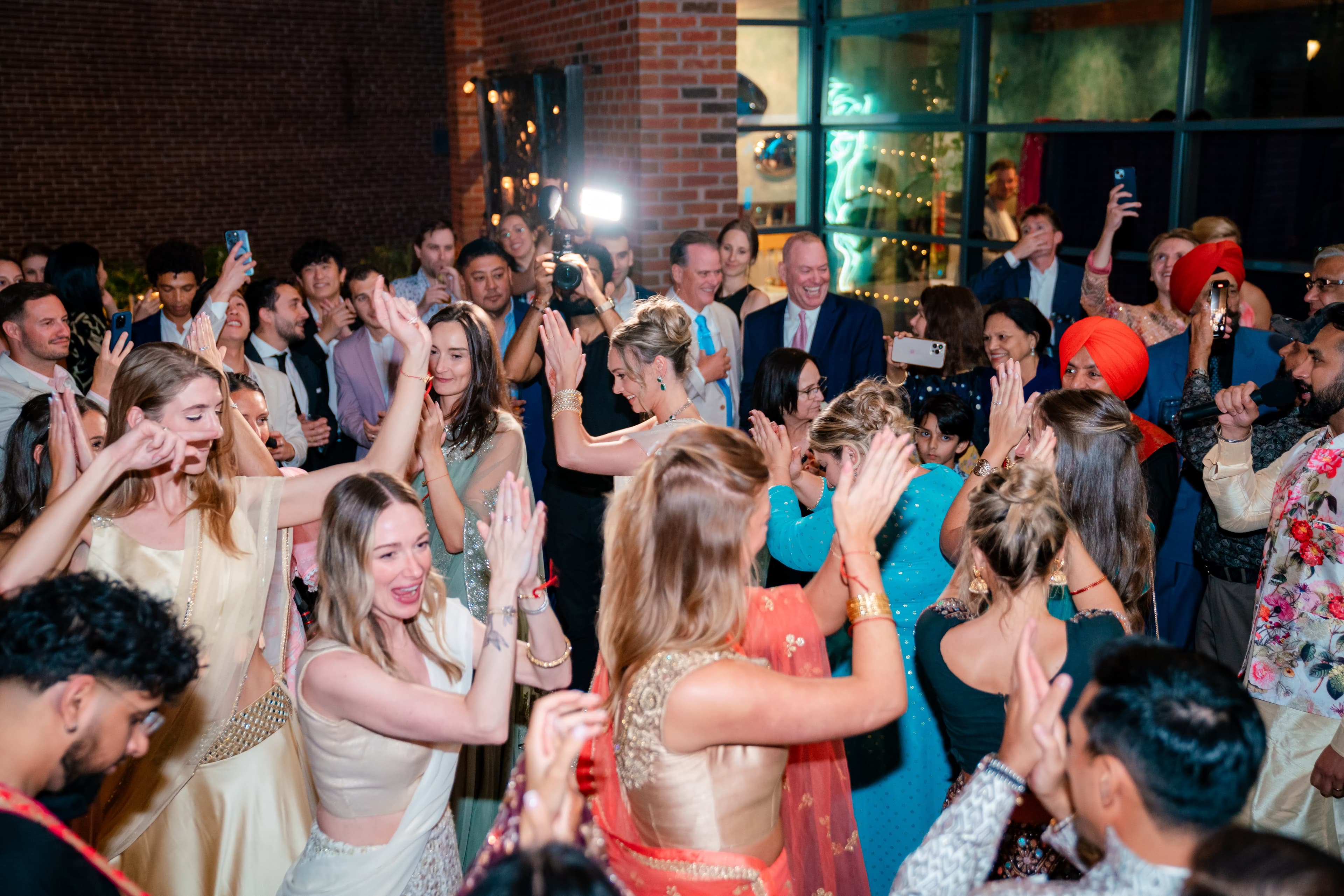 DJ Taj at a packed celebration with colorful lighting